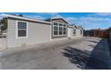 Modern single-story home with gray siding and a large concrete driveway at 3446 Cactus Springs Dr, Las Vegas, NV 89115