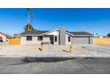 Remodeled single story home with gray exterior and wood fence at 4962 E Baltimore Ave, Las Vegas, NV 89104