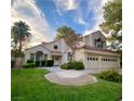 Two-story house with tile roof, landscaping, and a three-car garage at 5381 Waving Sage Dr, Las Vegas, NV 89149