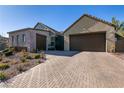 Modern home with a two-car garage and a brick paved driveway at 8435 Great Outdoors St, Las Vegas, NV 89166