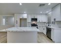 Renovated kitchen featuring white cabinets and a large quartz island at 8712 Majestic Pine Ave, Las Vegas, NV 89143