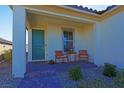 Inviting front porch with green door and seating area at 9577 Among Ln, Las Vegas, NV 89143