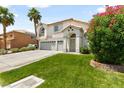 Two-story house with a three-car garage and lush green lawn at 1138 Aspen Valley Ave, Las Vegas, NV 89123