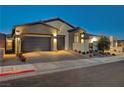 Two-car garage and inviting front entrance with landscaping at 11870 Star Grass Ave, Las Vegas, NV 89138