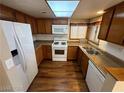 Kitchen with wood cabinets, white appliances, and wood flooring at 2235 High Dunes Ln, Laughlin, NV 89029