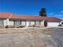 Front view of a ranch-style home with a red tile roof and attached garage at 2651 Homestead Rd, Pahrump, NV 89048