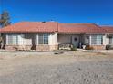 House exterior with red tile roof, landscaping, and a gravel driveway at 2651 Homestead Rd, Pahrump, NV 89048