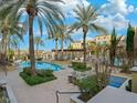 Community pool area with palm trees and lounge chairs at 30 Strada Di Villaggio # 339, Henderson, NV 89011