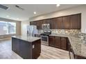 Modern kitchen with dark cabinetry, granite island, and stainless steel appliances at 4516 Townwall St, Las Vegas, NV 89115