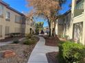 Landscaped courtyard with a walking path, desert plants, and trees at 5710 E Tropicana Ave # 2148, Las Vegas, NV 89122