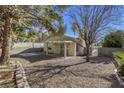 Backyard with gravel, covered patio, and mature trees at 5954 Wabusca Way, Las Vegas, NV 89142