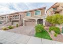 Two-story house with tan exterior, arched garage door, and landscaped front yard at 6034 Pirates Delight Ave, Las Vegas, NV 89139