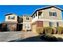 Two-story house with brick and siding, two-car garage, and landscaped yard at 7458 Mezzanine View Ave, Las Vegas, NV 89178