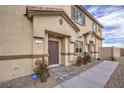 Townhome entrance with dark brown door and landscaping at 7835 Pandora Sky St # 461, North Las Vegas, NV 89084