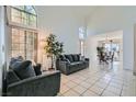 Bright living room features high ceilings, large windows, tile flooring, and comfortable seating at 3425 Trilogy Dr, Las Vegas, NV 89108