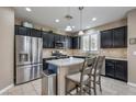 Spacious kitchen with dark cabinets, granite countertops, and stainless steel appliances at 7234 Regent Pond St, Las Vegas, NV 89166
