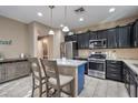 Modern kitchen with dark cabinetry, granite island, and stainless steel appliances at 7234 Regent Pond St, Las Vegas, NV 89166