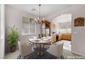 Cozy dining area adjacent to kitchen featuring a round table, elegant chandelier, and bright window at 805 Dana Hills Ct # 104, Las Vegas, NV 89134