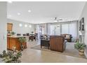 Open living room with leather furniture, fireplace, and large windows at 988 Buffalo River Ave, Henderson, NV 89002