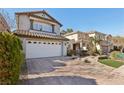 Two story house with a white garage door and mature shrubs at 11015 Dornoch Castle St, Las Vegas, NV 89141