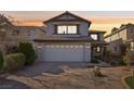 Beautiful sunset view of a two-story home with red tile roof and brick driveway at 11015 Dornoch Castle St, Las Vegas, NV 89141