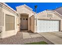 Front view of a beige house with a white garage door at 1570 Raining Hills St, Henderson, NV 89052