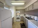 White appliances and light taupe cabinets in this galley kitchen at 2036 Mesquite Ln # 303, Laughlin, NV 89029