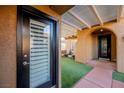 Front entry with black door and side glass door leading to a courtyard at 2149 Cedar River Ct, Henderson, NV 89044