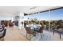Bright dining room with modern chandelier lighting, a glass table, and a stunning view of the city skyline at 3111 Bel Air Dr # 7F, Las Vegas, NV 89109