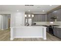 This large kitchen includes an island, stainless appliances, and gray cabinets at 4119 Amberdale Ave, North Las Vegas, NV 89031