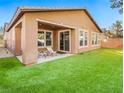 Artificial turf backyard with covered patio and seating area at 5625 Galivan Vista St, North Las Vegas, NV 89081
