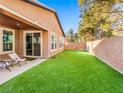 Artificial turf backyard with covered patio and seating area at 5625 Galivan Vista St, North Las Vegas, NV 89081