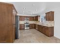 Bright kitchen features granite countertops, stainless steel appliances, tile backsplash, and wooden cabinets at 7220 Stormson Dr, Las Vegas, NV 89145