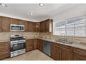 Well-lit kitchen with granite countertops, stainless steel appliances, tile backsplash, and wooden cabinets at 7220 Stormson Dr, Las Vegas, NV 89145
