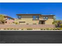 Tan two-story home with a large backyard and wall at 7611 Phoenix Peak St, Las Vegas, NV 89166