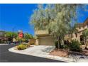 Tan two-story home with attached garage and mature trees at 7611 Phoenix Peak St, Las Vegas, NV 89166