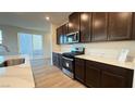 Contemporary kitchen showcases sleek stainless steel appliances and quartz counters next to backyard access at 7308 Davenbury St, Las Vegas, NV 89113