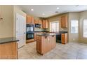 Kitchen with island, wood cabinets, and granite countertops at 9893 Cove Haven Ct, Las Vegas, NV 89178