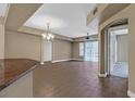 Open-concept living room and dining area with elegant lighting and beautiful tile floors at 26 E Serene Ave # 124, Las Vegas, NV 89123