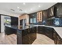 Modern kitchen featuring sleek black cabinets, a large island with granite countertops, and stainless steel appliances at 3738 Falcon Springs Dr, Las Vegas, NV 89147
