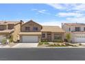 Tan two-story house with tile roof, white garage door, and landscaping at 5000 Forest Oaks Dr, Las Vegas, NV 89149