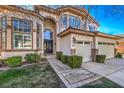 Front view of two-story house with two-car garage and well-manicured landscaping at 5423 San Florentine Ave, Las Vegas, NV 89141