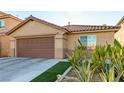 Tan house with brown garage door, cacti, and desert landscaping at 6349 Heather Creek Place Pl, Las Vegas, NV 89122