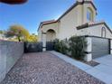 Two-story house with a gray garage door and desert landscaping at 8101 Tribal Cir, Las Vegas, NV 89145