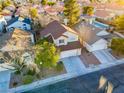 Aerial view of two story house with front yard, driveway and community pool in view at 8113 Bay Springs Dr, Las Vegas, NV 89128