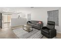 Living room with gray sofa, recliner, and a wood-look floor at 104 Masserta Ct, Las Vegas, NV 89183