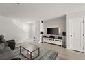 Living room with gray sofa, media console, and flat-screen TV at 104 Masserta Ct, Las Vegas, NV 89183