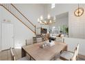 Bright dining room with a modern chandelier and staircase featuring carpeted steps and white banisters at 561 Tecate Valley St, Las Vegas, NV 89138