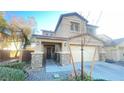 Two-story house with stone accents, attached garage, and landscaping at 59 Dreamy Hill Ave, North Las Vegas, NV 89031