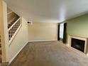 Spacious living room with a fireplace, staircase, neutral paint, carpet, and natural light from a large window at 8441 Blue Island Ave, Las Vegas, NV 89129